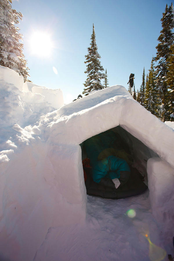 Snow trench shelter on for winter photography trip with sleeping bags visible, a lightweight and insulated alternative to tents in winter conditions