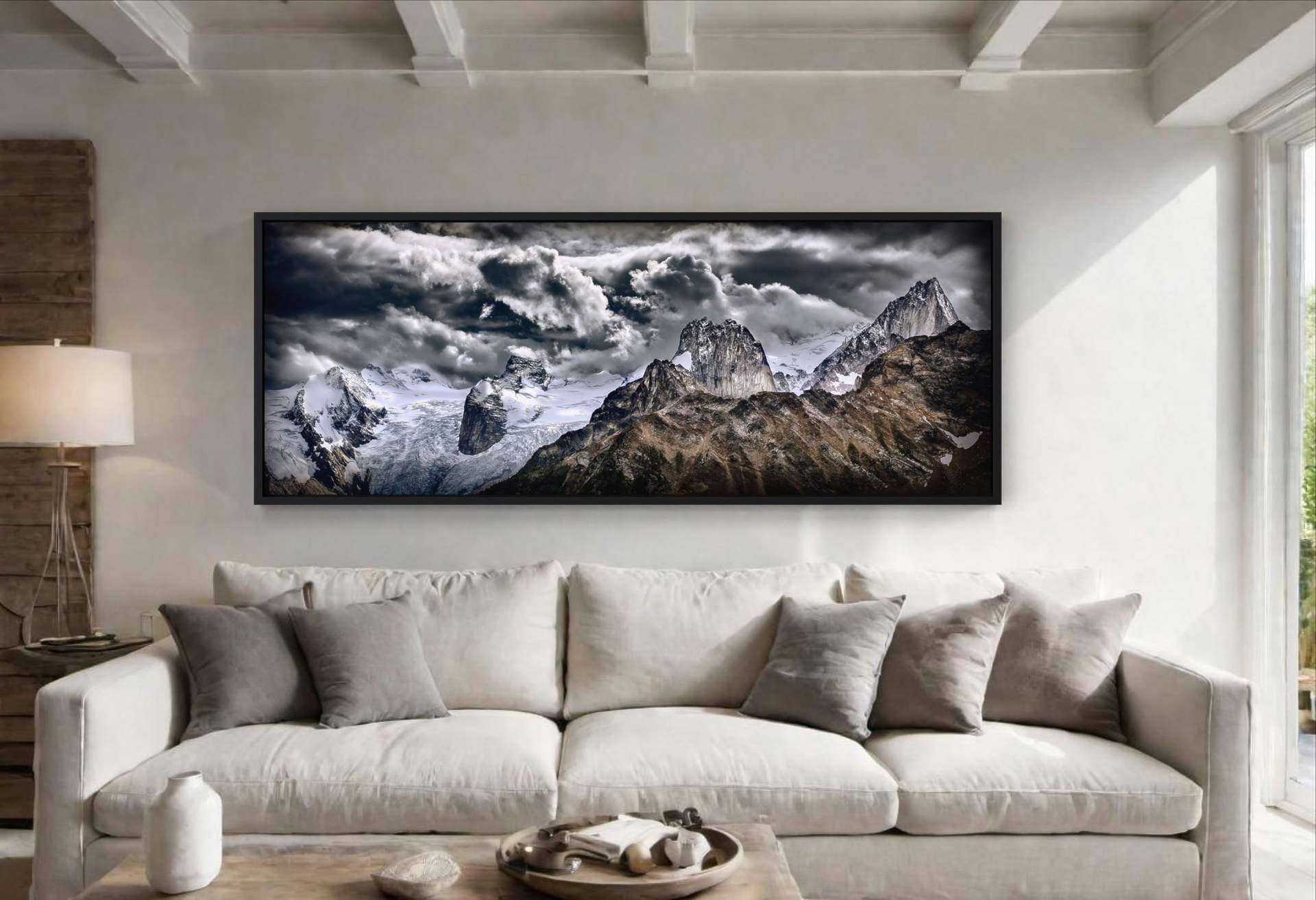 Contemporary living room with 'Bugaboo Skyline' by Howard Smith, a panoramic mountain-themed print, as the centerpiece above a plush sofa, framed elegantly in black