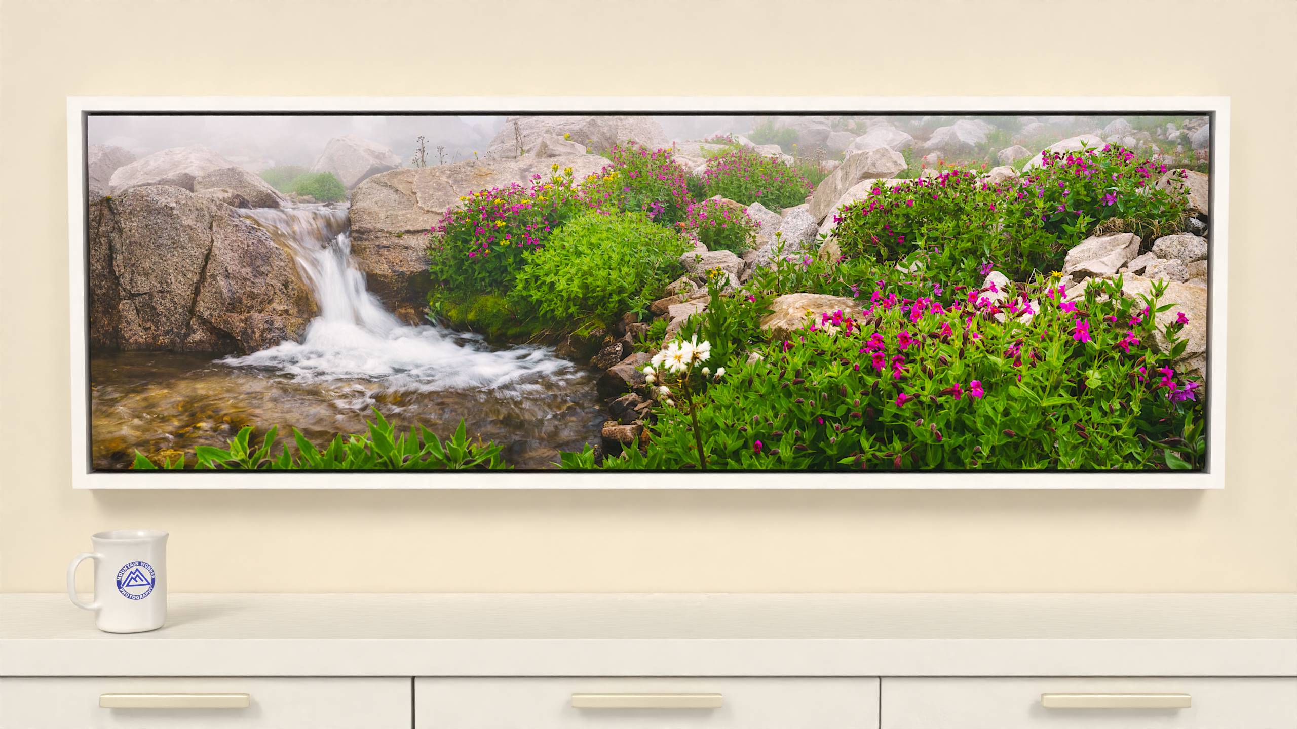 60x19 inch Wrapped canvas print with white floater frame. Enchanting canvas print of a mist-shrouded alpine stream, small waterfall, and stunning wildflowers.